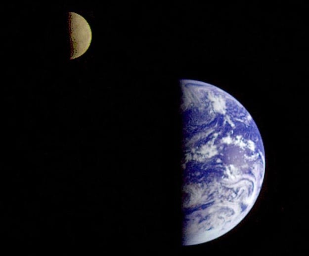 A photo taken by the Galileo spacecraft from about 6.3 million kilometers away, with Earth and moon both half-lit by the sun.